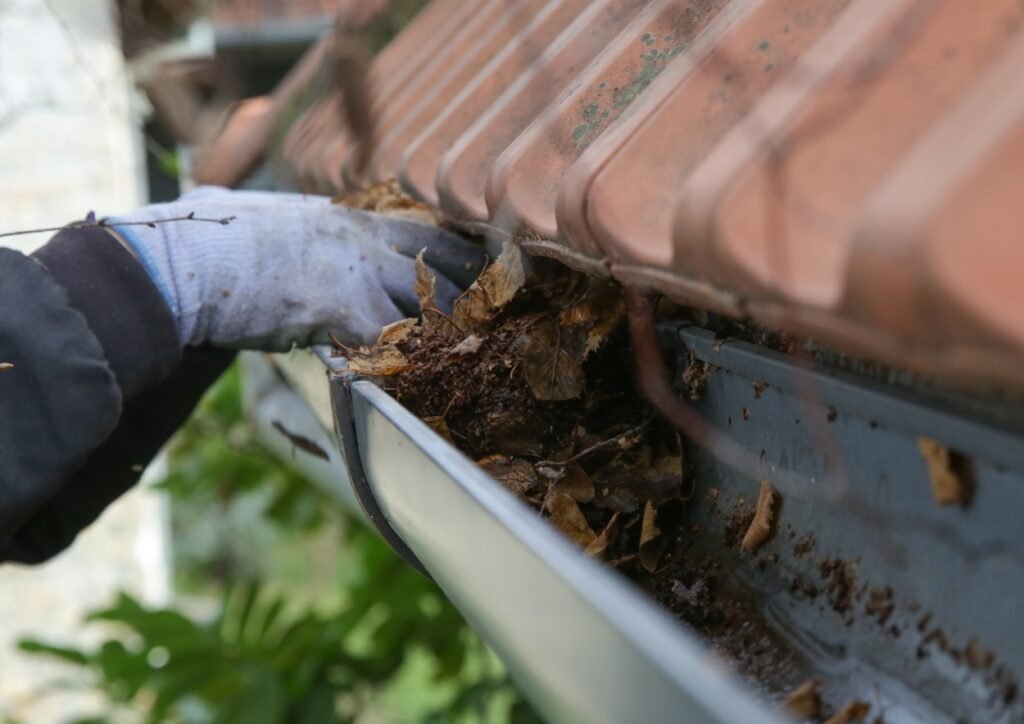 Photo montrant la mise en application d'un nettoyage de gouttière à la main.